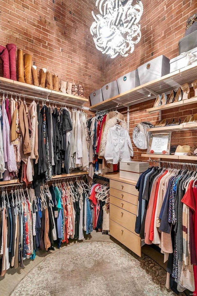 spacious closet featuring a notable chandelier