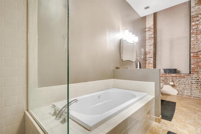 bathroom with toilet and tiled tub