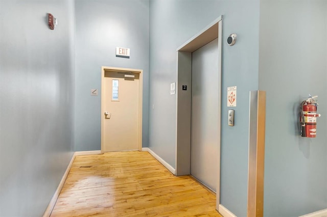 hall featuring light hardwood / wood-style flooring and elevator