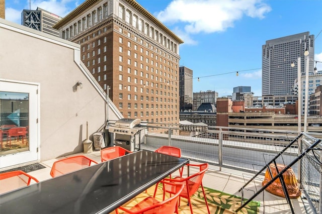 view of patio with area for grilling and a balcony