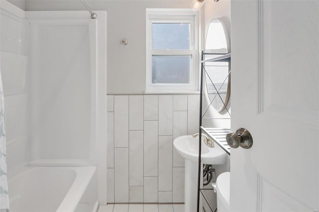 bathroom with  shower combination, tile patterned flooring, and tile walls