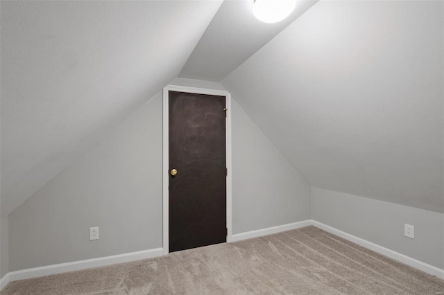 additional living space featuring carpet floors and vaulted ceiling