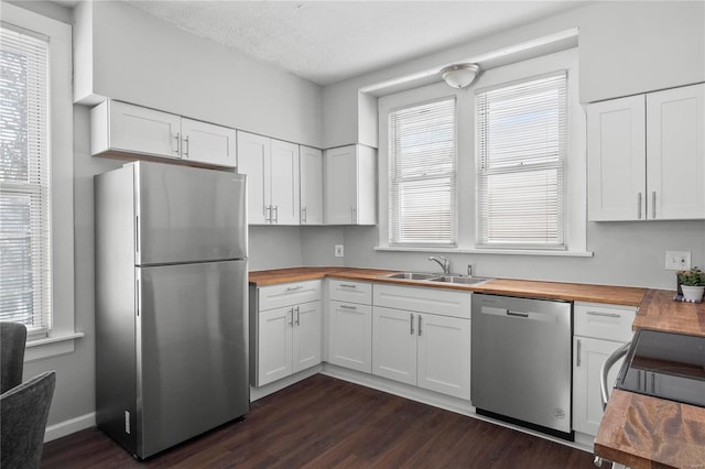 kitchen featuring wooden counters, white cabinets, and appliances with stainless steel finishes