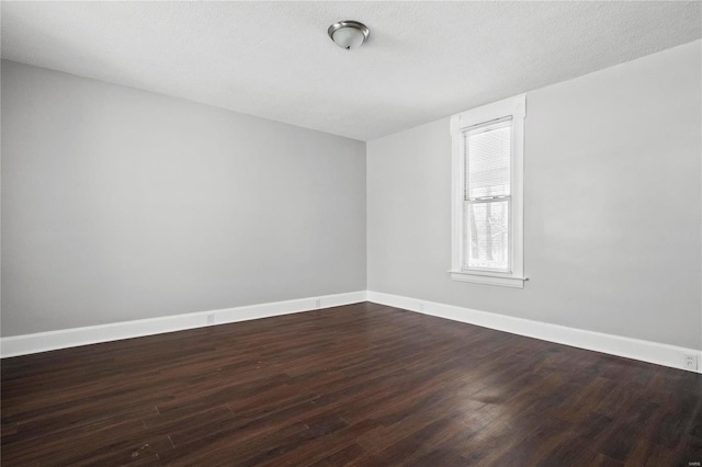 empty room with wood-type flooring and a textured ceiling