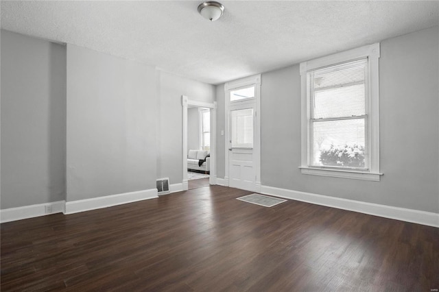 interior space with a textured ceiling and dark wood-type flooring