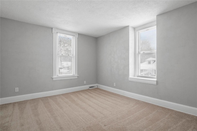 spare room with a textured ceiling and carpet floors