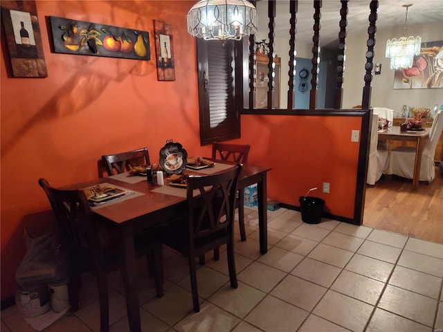 tiled dining room with an inviting chandelier