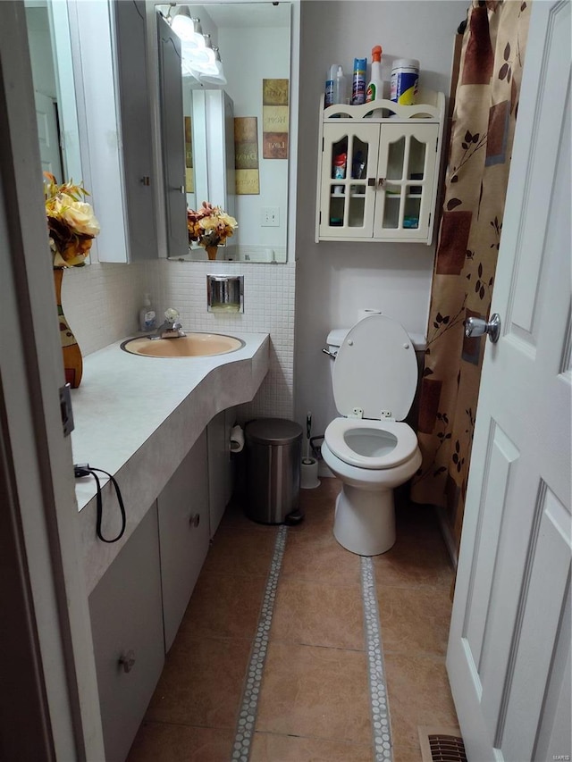 bathroom featuring toilet, tile patterned flooring, vanity, and decorative backsplash