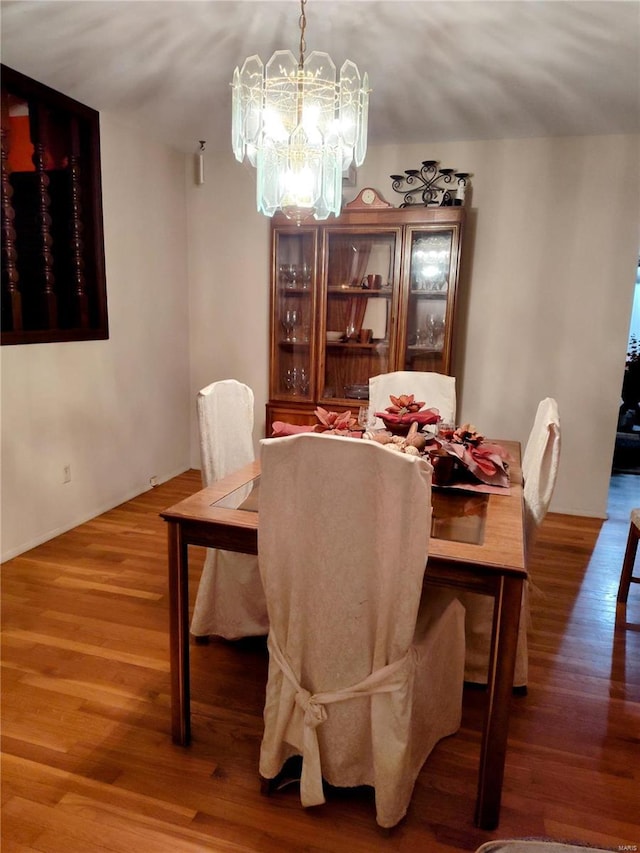 dining space with a chandelier and wood-type flooring