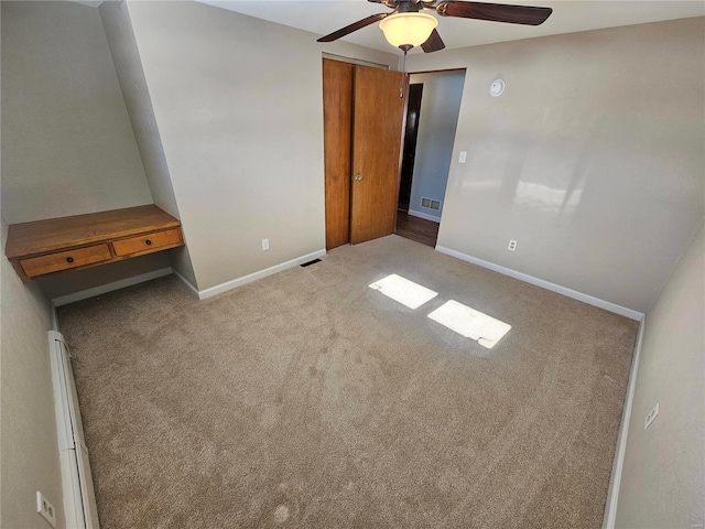 unfurnished bedroom featuring ceiling fan and light carpet