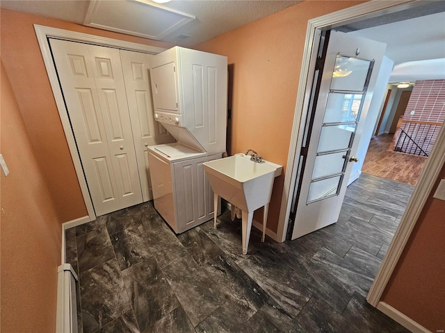 clothes washing area featuring stacked washer and dryer, ceiling fan, and sink