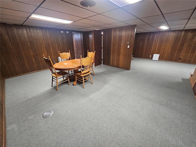 unfurnished dining area featuring light colored carpet and a drop ceiling