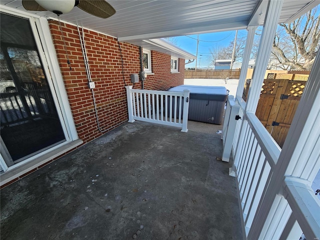 view of patio / terrace with ceiling fan and a hot tub