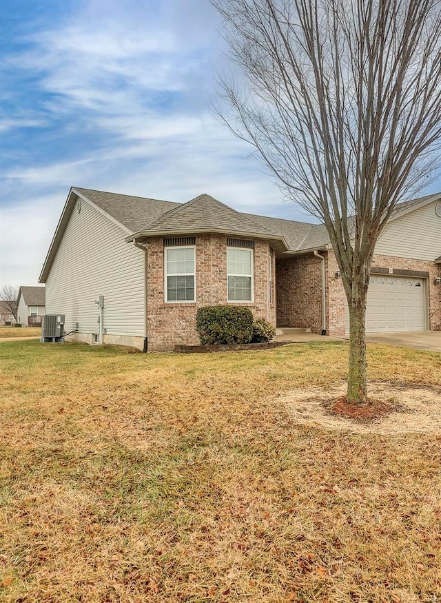 ranch-style home with central AC, a garage, and a front lawn