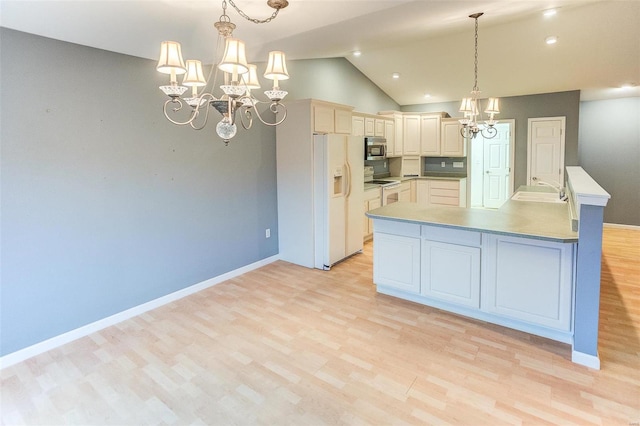 kitchen featuring pendant lighting, white appliances, an inviting chandelier, vaulted ceiling, and light wood-type flooring