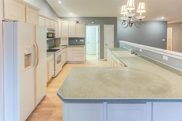 kitchen featuring an inviting chandelier, decorative light fixtures, sink, white appliances, and light wood-type flooring