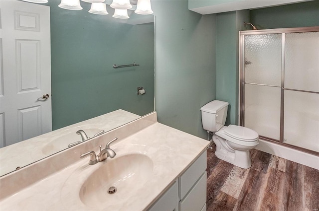 bathroom with walk in shower, wood-type flooring, toilet, and vanity