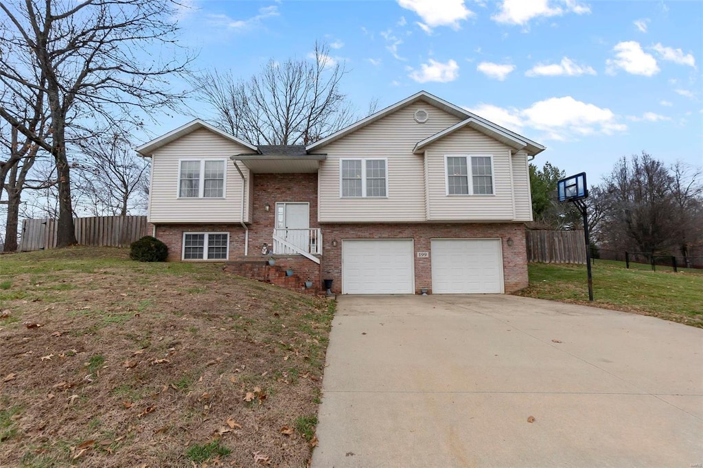 split foyer home featuring a front lawn and a garage