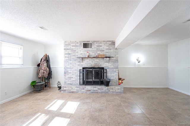 unfurnished living room featuring light tile patterned flooring, a brick fireplace, and a textured ceiling