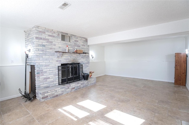 unfurnished living room featuring a brick fireplace and a textured ceiling