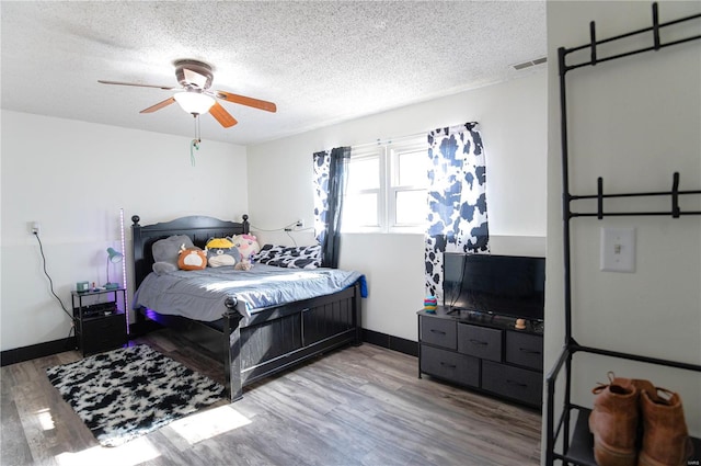 bedroom featuring ceiling fan, light hardwood / wood-style floors, and a textured ceiling