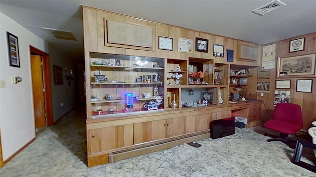 carpeted office featuring wood walls