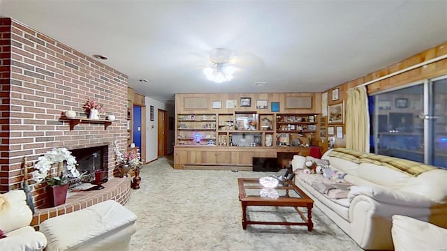 carpeted living room featuring wood walls and a fireplace