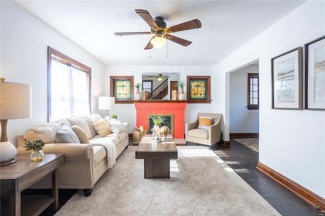 living room featuring a brick fireplace and ceiling fan