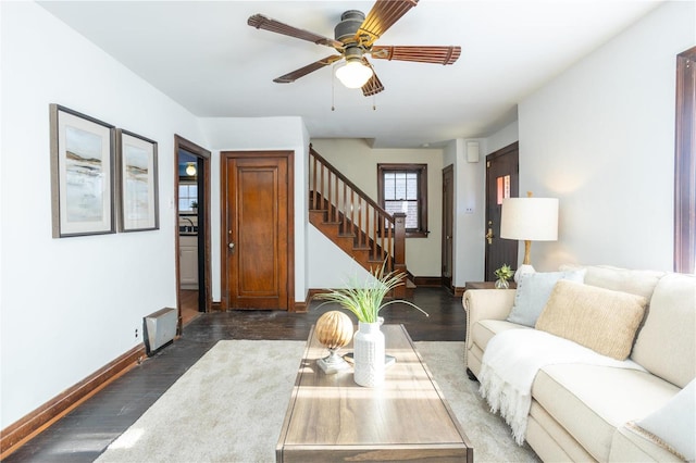 living room featuring ceiling fan and dark wood-type flooring