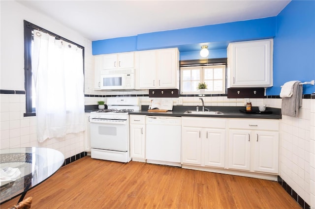 kitchen featuring sink, white appliances, white cabinets, and light wood-type flooring