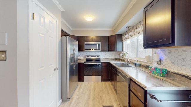 kitchen with stainless steel appliances, decorative backsplash, sink, dark brown cabinets, and crown molding