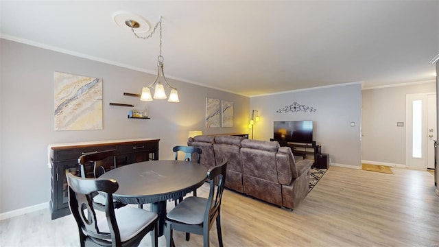 dining room with light wood-type flooring, a notable chandelier, and crown molding