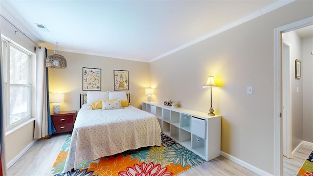 bedroom with light wood-type flooring and crown molding