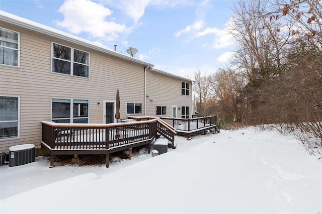 snow covered rear of property with central air condition unit and a wooden deck