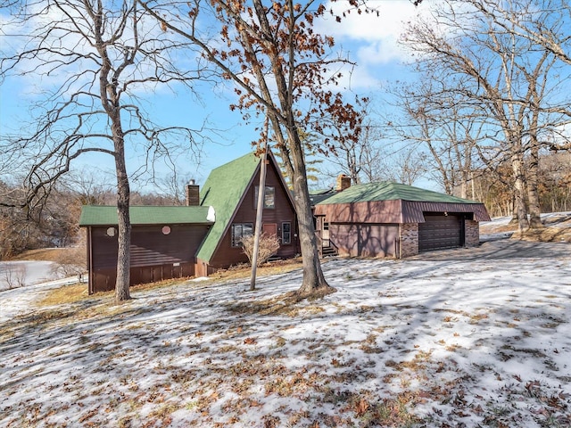 view of snow covered exterior with a garage