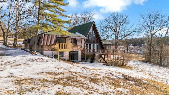 snow covered property with a deck