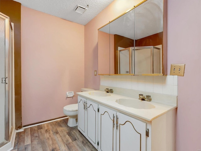 bathroom with walk in shower, toilet, wood-type flooring, a textured ceiling, and vanity