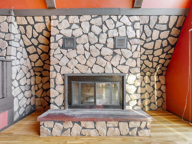 room details featuring a stone fireplace and hardwood / wood-style flooring