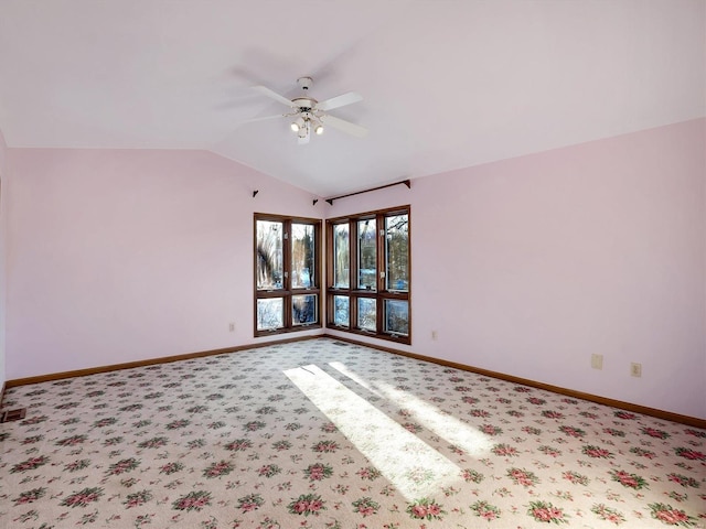 carpeted empty room with vaulted ceiling and ceiling fan