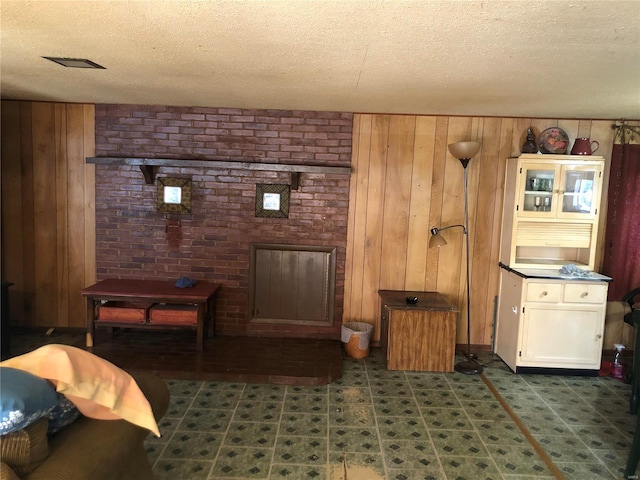 living room with wood walls and a textured ceiling