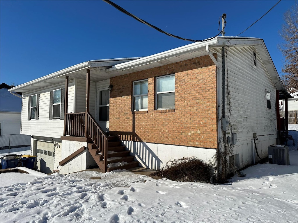 view of front of home featuring central AC unit and a garage