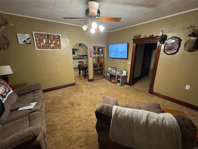 carpeted living room with ceiling fan and crown molding