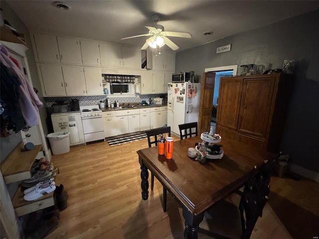 kitchen featuring white appliances, light hardwood / wood-style flooring, backsplash, white cabinets, and ceiling fan