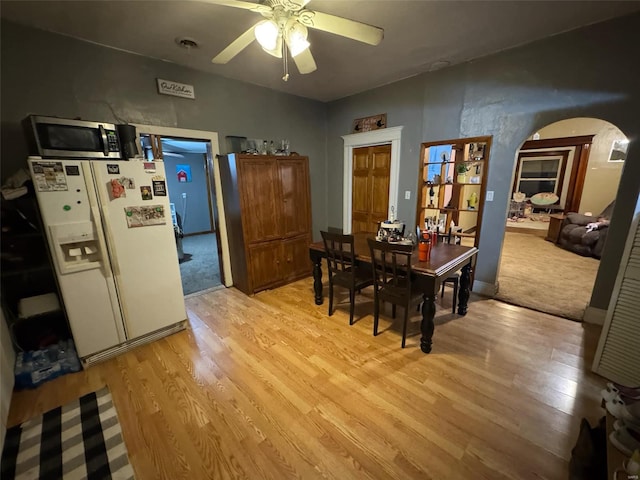 dining space with ceiling fan and light wood-type flooring