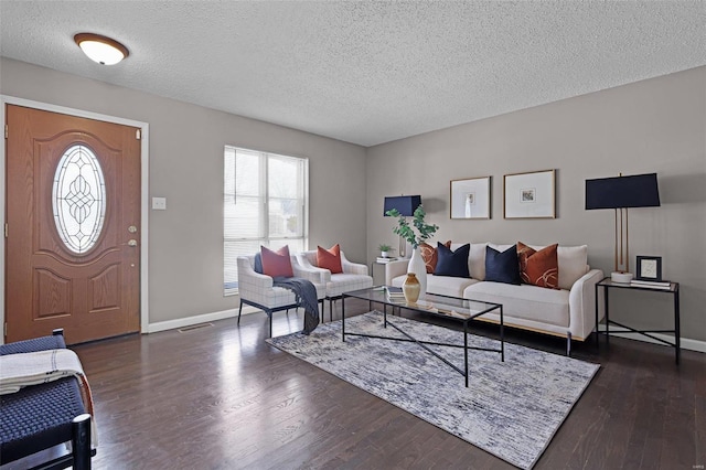 living room with a textured ceiling and dark hardwood / wood-style floors