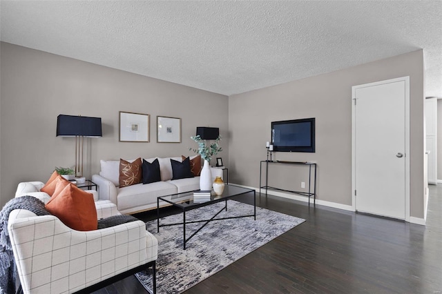 living room featuring dark wood-type flooring and a textured ceiling