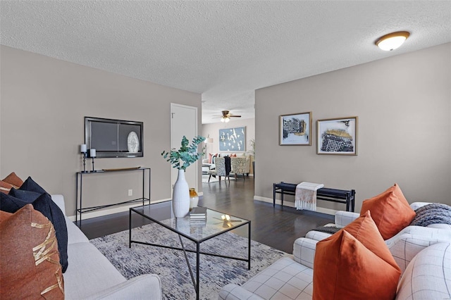 living room with ceiling fan, a textured ceiling, and hardwood / wood-style floors