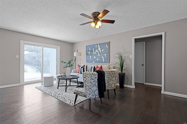 living room with ceiling fan, dark wood-type flooring, and a textured ceiling