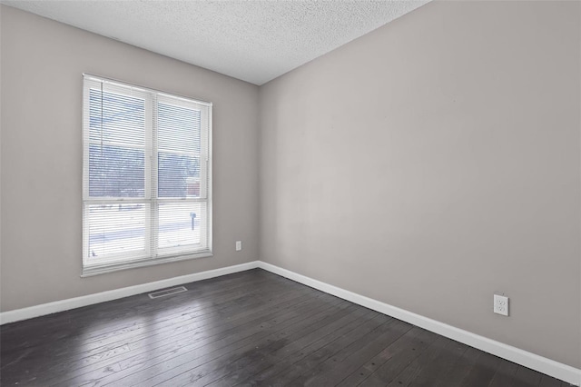 unfurnished room with dark hardwood / wood-style floors and a textured ceiling