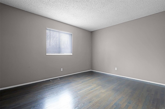 unfurnished room with dark hardwood / wood-style flooring and a textured ceiling